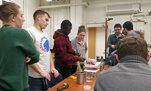 students working on electronics of a chemically powered vehicle for a Chem-E-Car competition