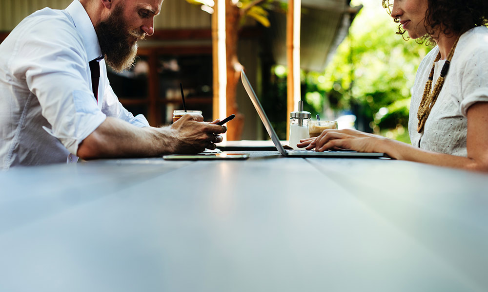 Feature image two people, a man and a woman, working on laptops