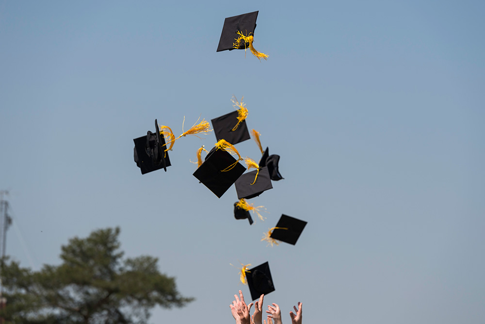 graduation caps being thrown in the air