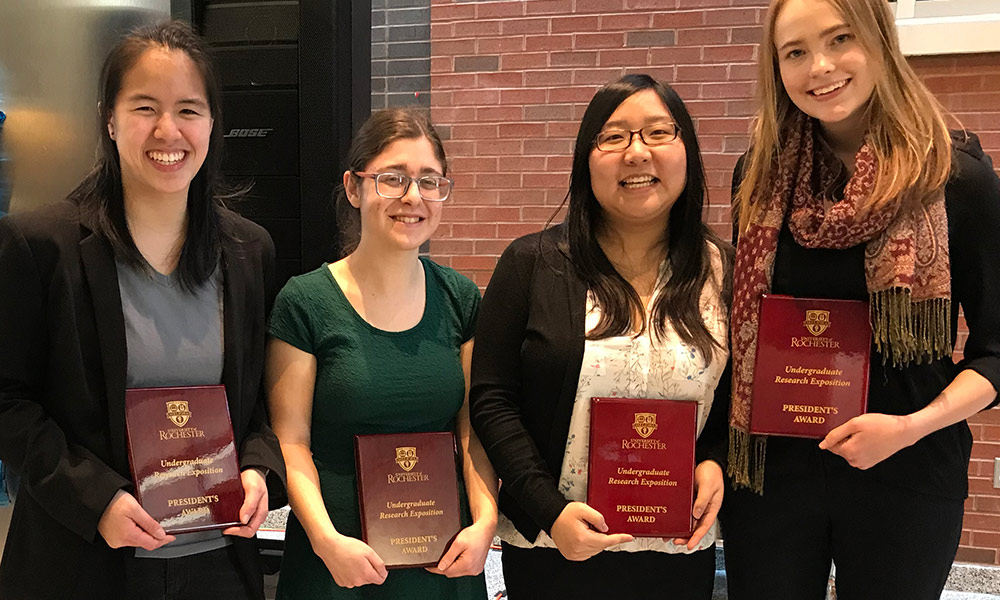 four students holding awards