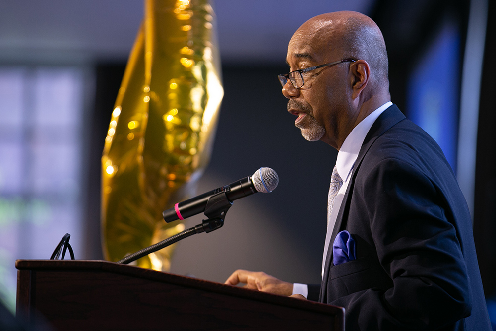 Norman Burnett speaking at a podium