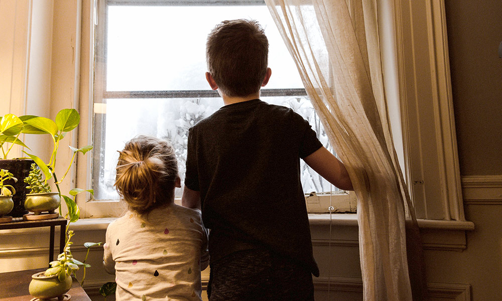 Feature image older brother and younger sister looking out a window