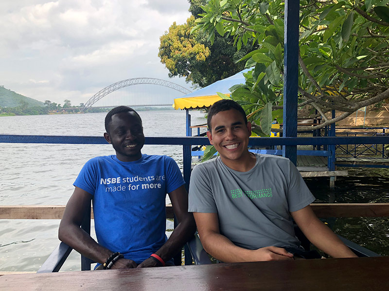 two students seated at a restaurant table, smiling