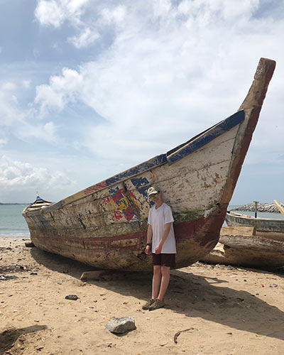 young man leaning against the hull of a boat