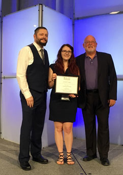 portrait of three people receiving an award
