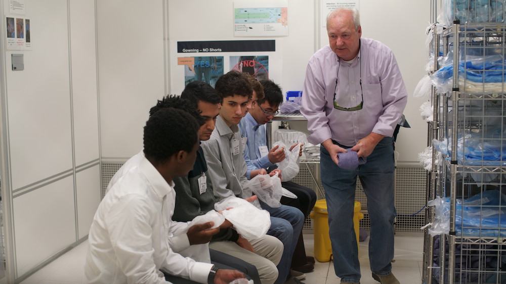 lab staffer with students in a clean room