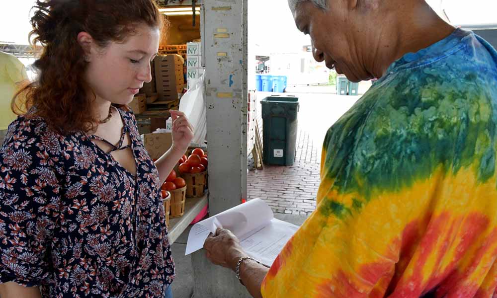 Summer Sustainability Fellow asks Rochester resident to complete a climate change survey.