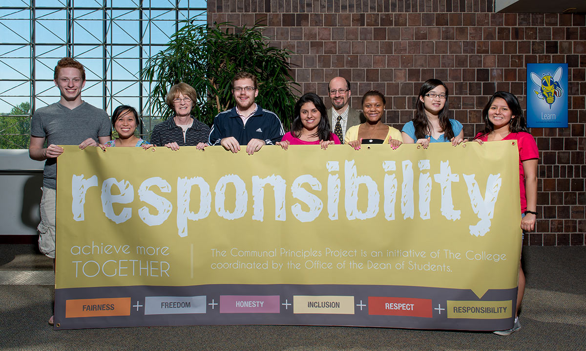 students and staff holding a banner celebrating the Year of Responsibility, one of the University's communal principles