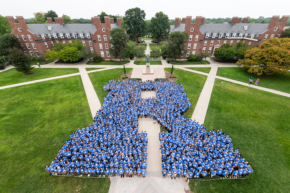 Feature image overhead shot of large group of students arranged to form the letter R