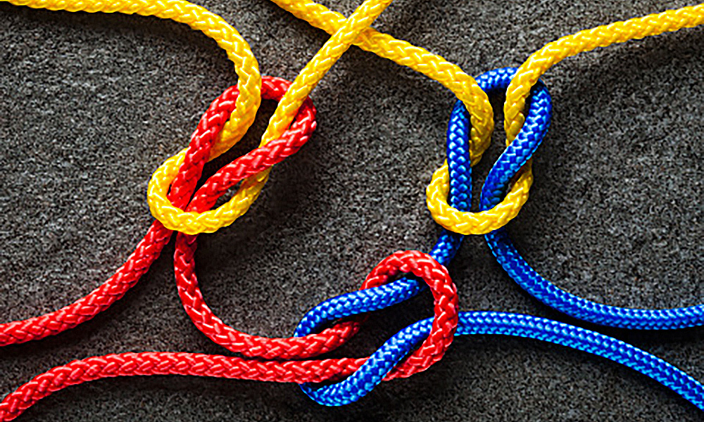 three brightly colored strings each tied to the other with a square knot