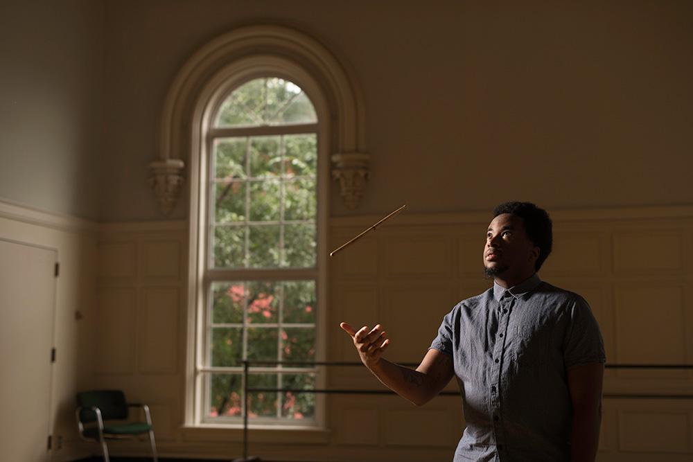 D'Jean Vasciannie tossing a drumstick into the air