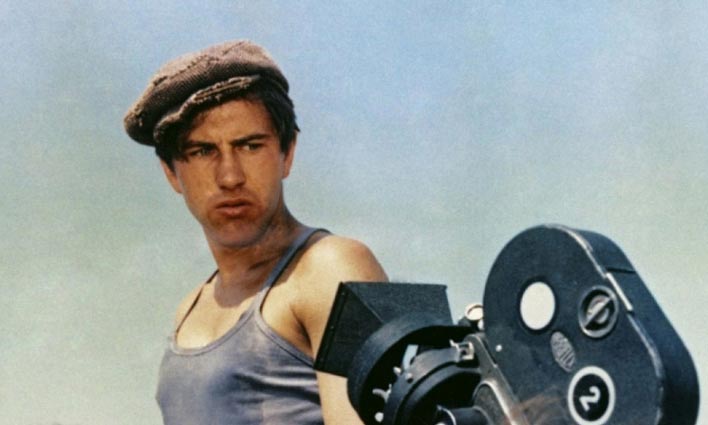 Feature image scene from Man of Marble showing man in a newsboy cap staring at a 1930s film camera