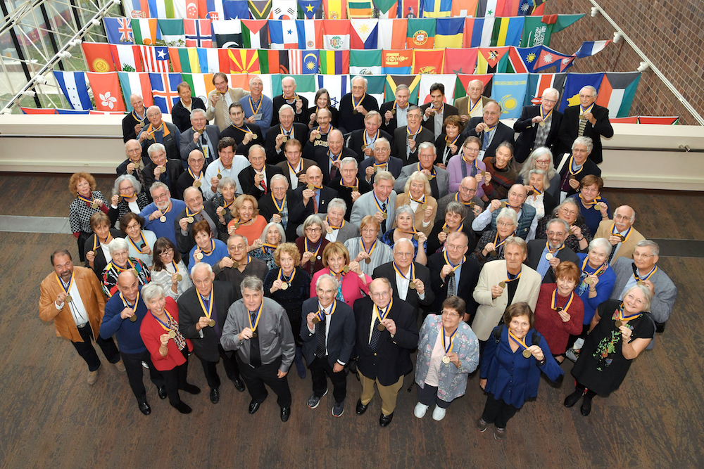 group of alumni hold medals