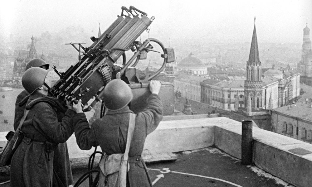 Feature image historical image of world war II soldiers operating a large gun on top of a building with the Moscow skyline in the background.