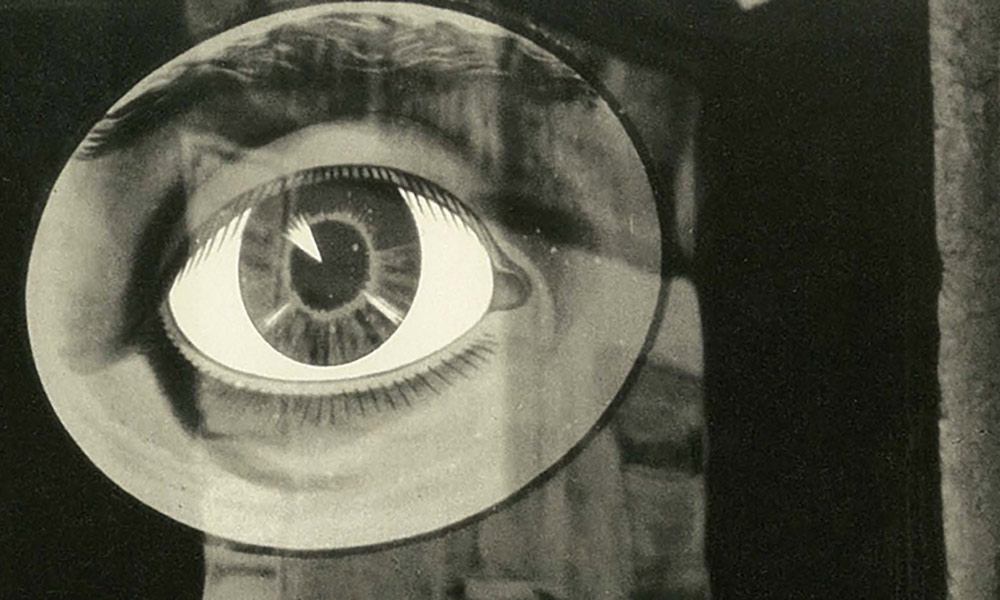 Feature image detail from a black and white photograph shows a close-up drawing of an eye