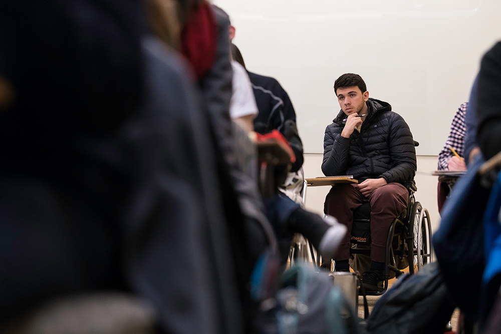 Giuliano Agostinho de Castro sitting in a classroom full of fellow students