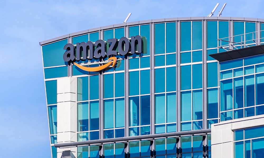exterior of tall, glass building with the Amazon logo on the side representing Amazon HQ2 finalists