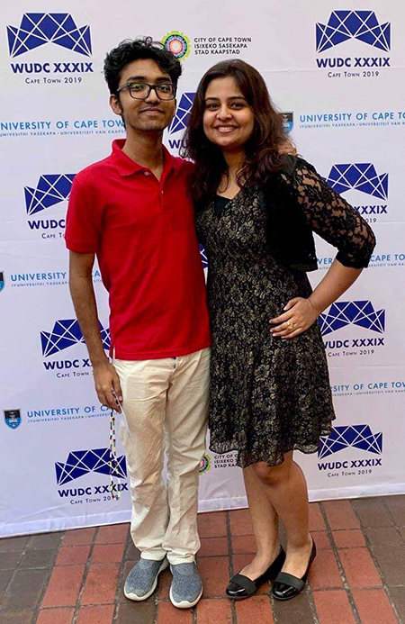 two students pose for a portrait in front of a backdrop with the WUDC Cape Town 2019 logo