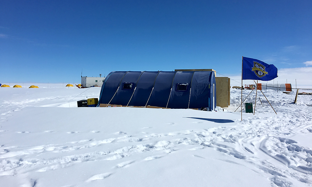 Feature image A blue tent sits on a field of ice and snow, with a University of Rochester MELIORA flag flying in front.