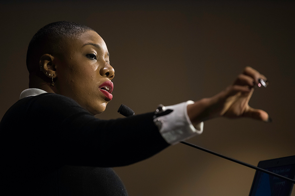 Symone Sanders gesturing from behind the podium.