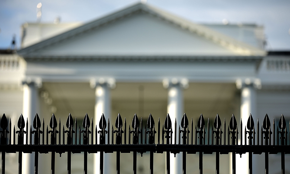 fence in front of blurred image of White House