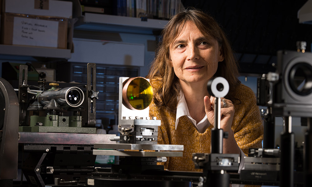 Feature image Jannick Rolland in her lab surrounded by lenses and other optical equipment.