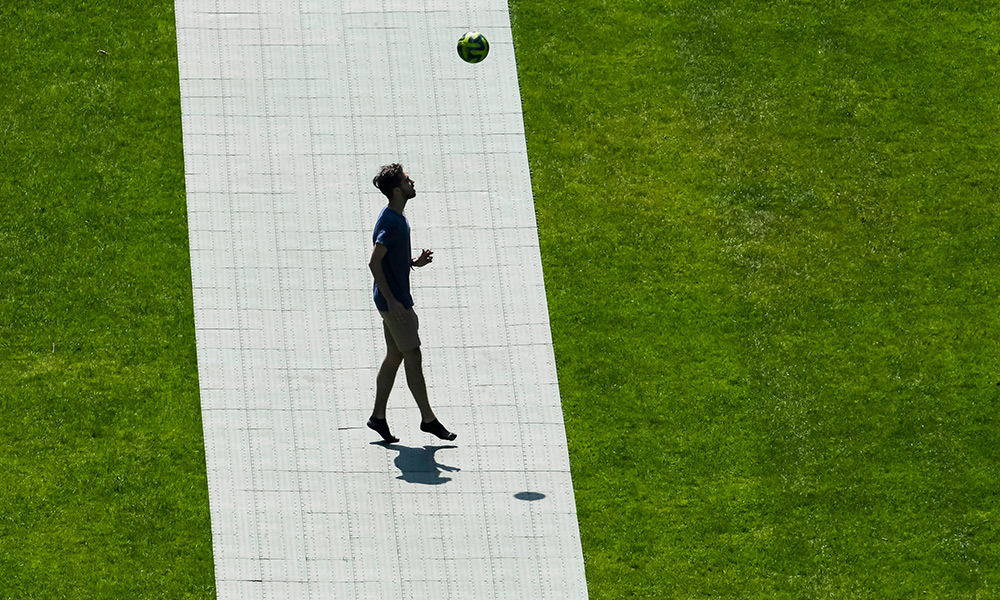 Feature image student playing soccer alone on the quad.