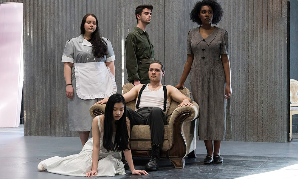 Feature image group of actors pose on a stage.