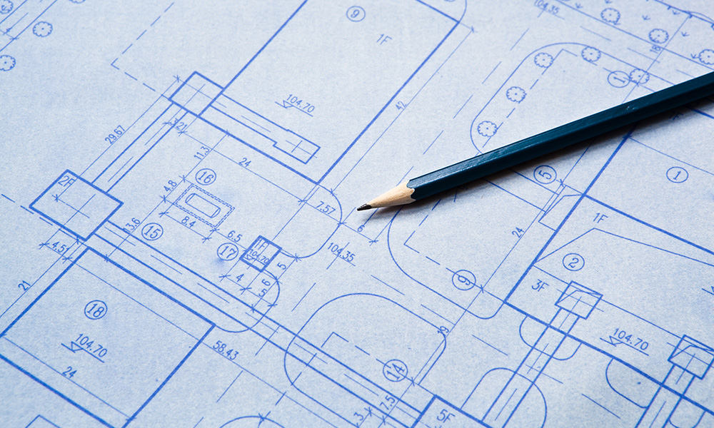 blueprints with a pencil.