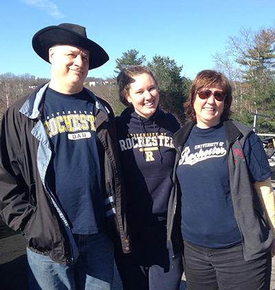 graduate posing with her parents
