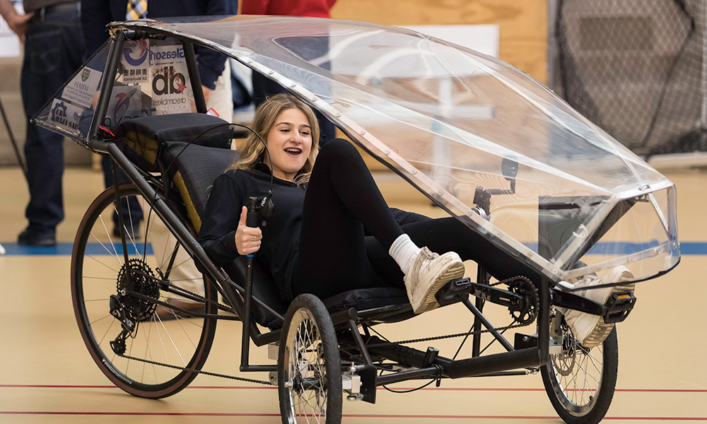 student pedaling a human powered vehicle