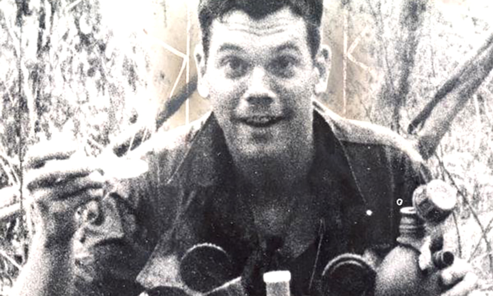 Feature image archival photo of soldier smiling, holding a canteen