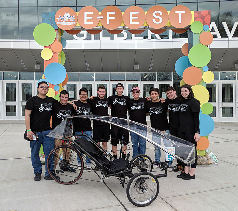 a team of students pose with their human-powered vehicle