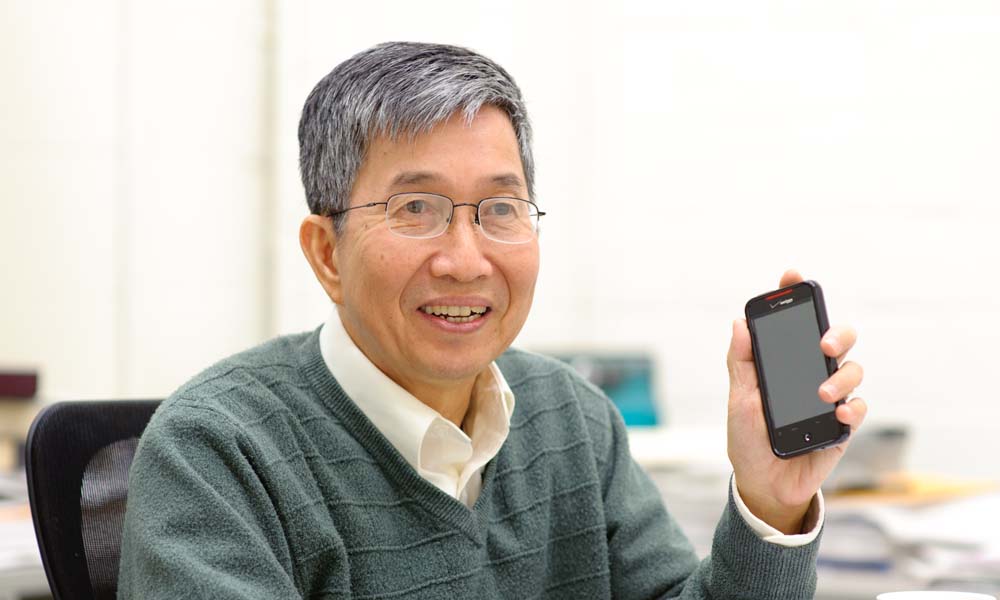 Feature image Ching Tang holds a smartphone that uses Organic Light Emitting Diodes (OLED) technology.