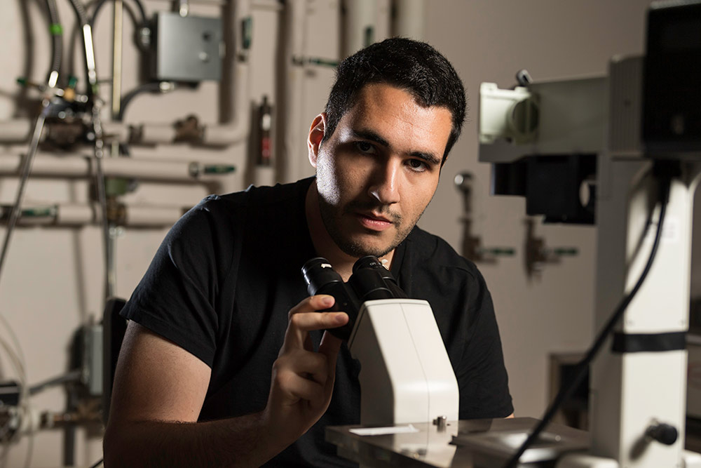 student looks up from a microscope