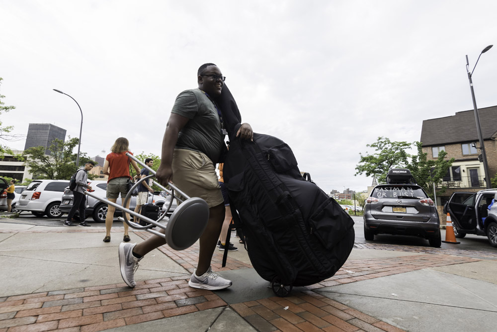 student pushing an upright bass.