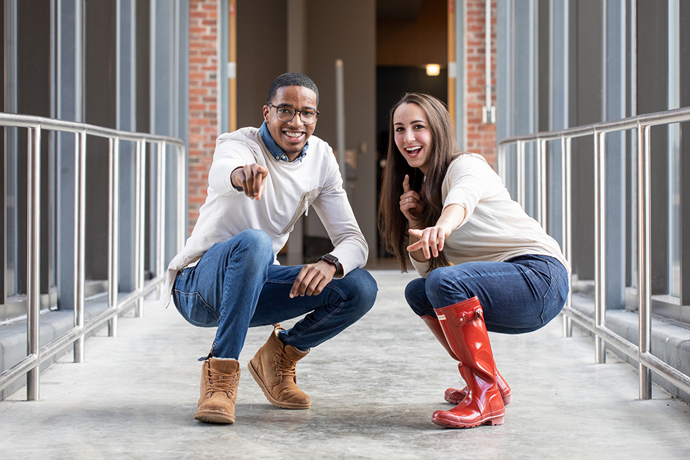 two students pointing at the camera