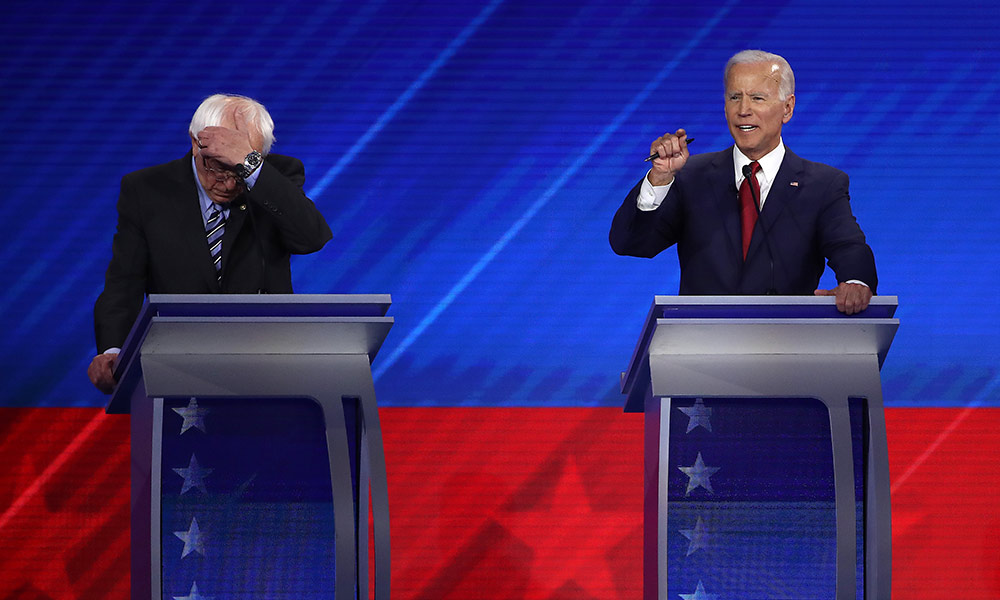Feature image Joe Biden and Bernie Sanders on stage during the democratic debate.