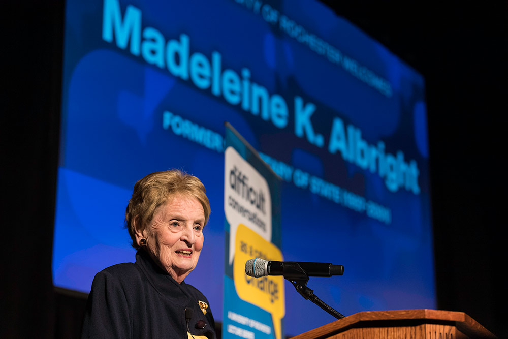 Feature image Madeleine Albright on stage in front of a screen that bears her name