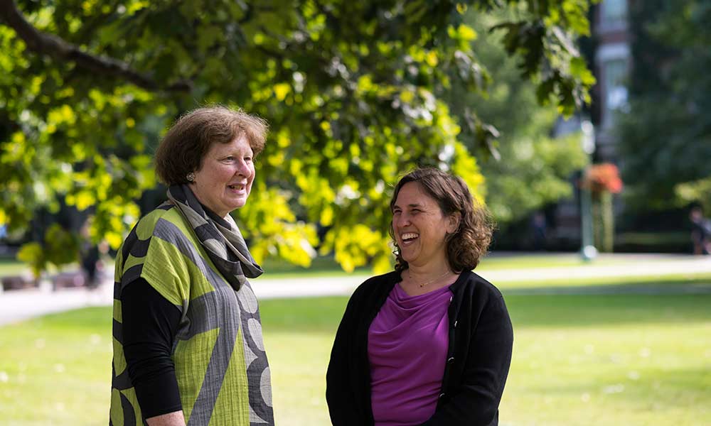 Joan Rubin and Wendi Heinzelman talking and laughing on the quad.