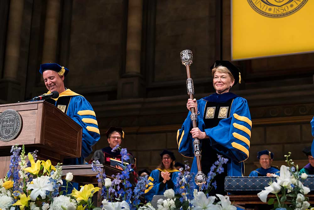 Sarah Mangelsdorf on inauguration stage, holding University mace