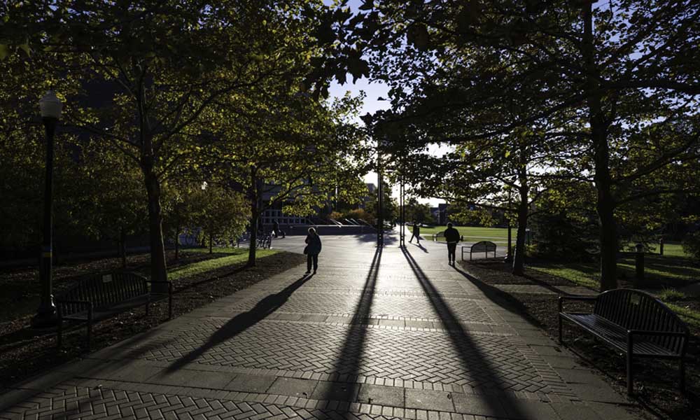 Feature image Students walk through Dandelion Square in the fall..