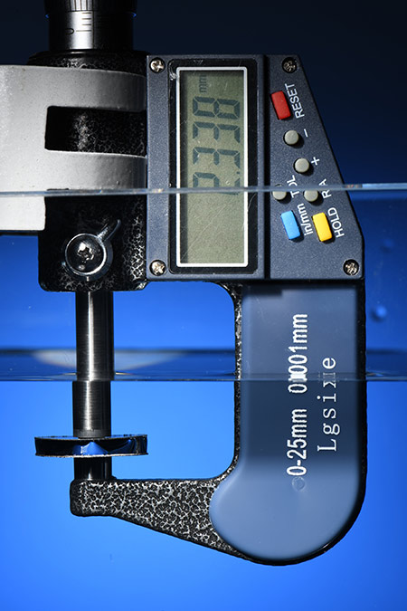 a measuring device submerged in water measures the distance between two thin discs of superhydrophobic metal.