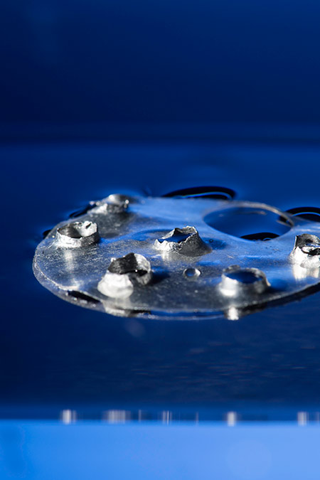 a superhydrophobic metallic disc punctured with multiple holes.