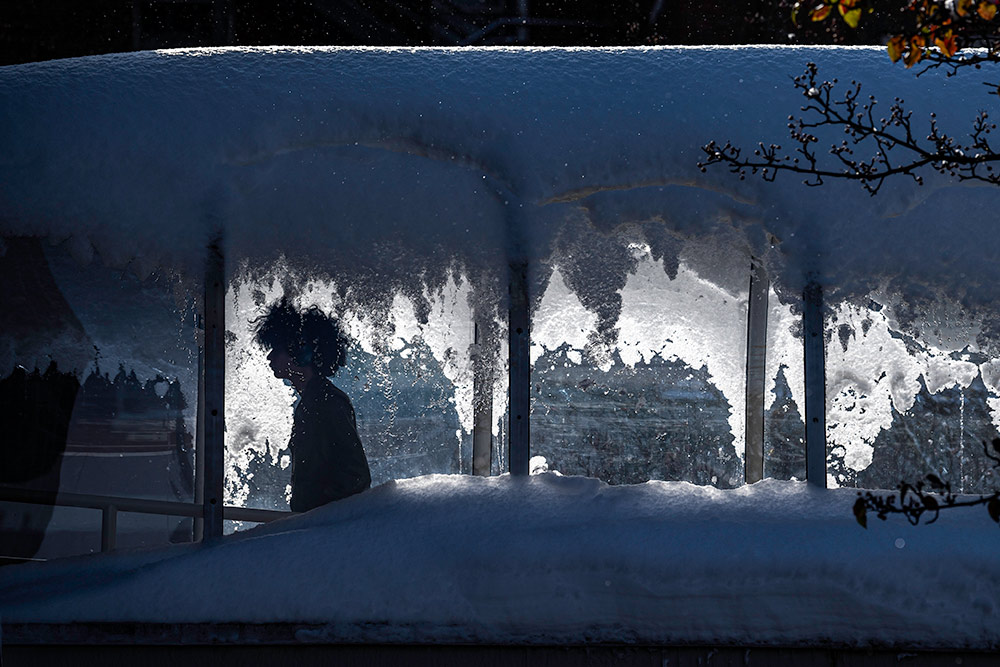 photo of a student silhouetted against an icy window.