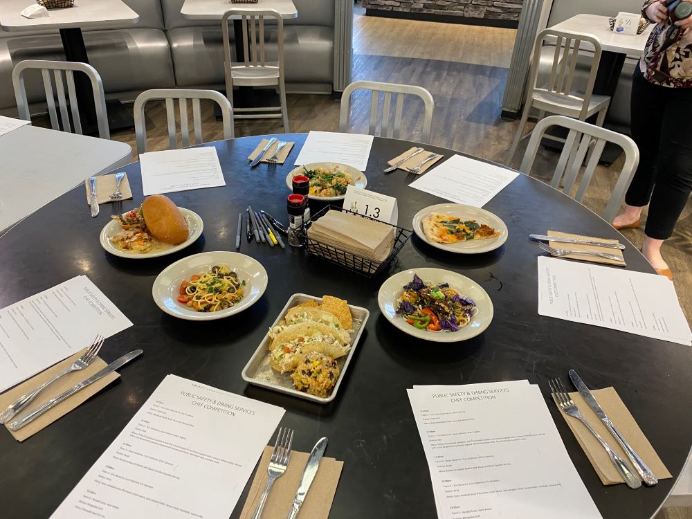 table filled with six dishes and voting ballots. 