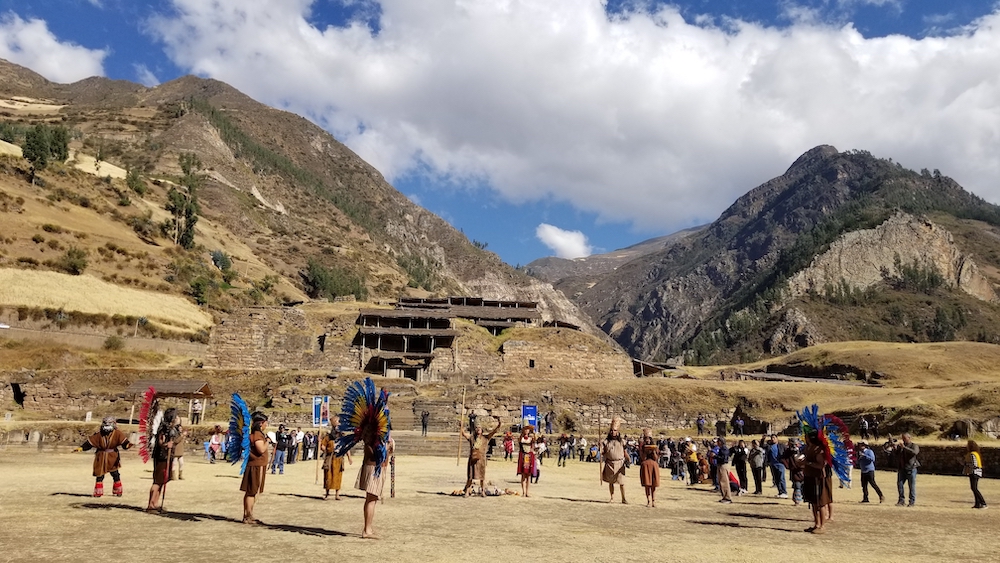 group of people standing with mountains in the background