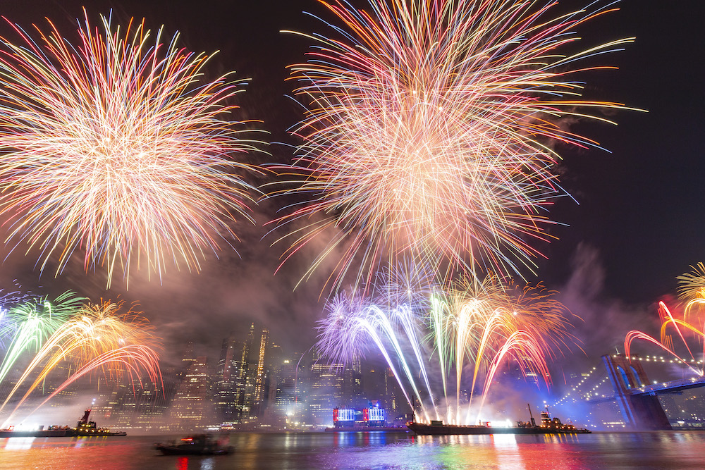 fireworks display over water and city skyline