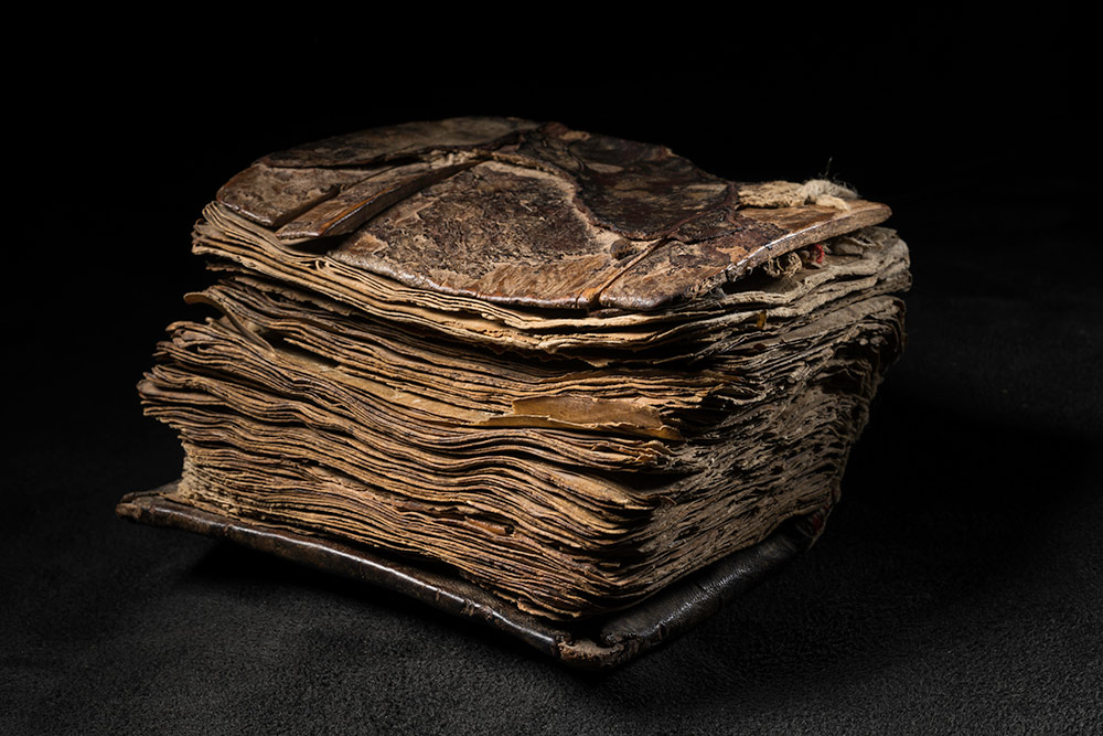 close up of the small book from the side, its pages compressed together.