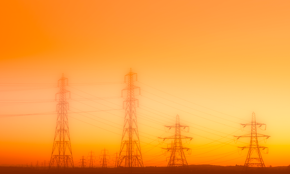 Feature image electrical power lines against the backdrop of a hazy sky.